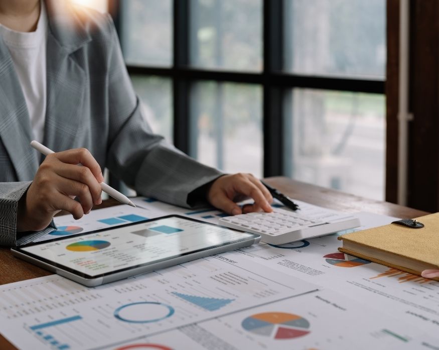 Service image box featuring people analyzing financial information on a tablet.